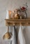 Cozy  kitchen scandinavian interior - wooden shelf with lighted candles,  jar of cookies,  jug and linen towels on a hanger in