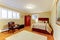 Cozy large guest room with suede brown bed and armor, hardwood floors and beige walls.