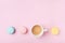 Cozy morning breakfast. Cup of coffee and colorful macaron on pastel pink background top view. Fashion flat lay. Sweet macaroons.