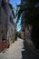 Cozy narrow beautiful street in the old turkish town Alacati, Turkey with houses twined with bougainvillea