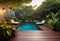 Cozy patio in the back garden with wooden decking, tropical plants and plunge pool. modern design of a place to relax at home,