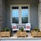 A cozy peaceful front porch of a house with adirondack chairs and flower planters