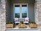 A cozy peaceful front porch of a house with adirondack chairs and flower planters