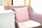 Cozy pink armchair near white table.