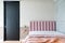 Cozy Pink Bedroom corner with baby pink velvet fabric bed decorated by blanket, pillows and pink floor lamp with two-tone beige