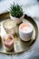 Cozy real home decoration, burning candles on golden tray with pillow on white faux fur on windowsill