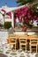 Cozy restaurant under flowering trees in the street of Chora in Mykonos, Cyclades Island. Greece