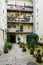 Cozy romantic courtyard with many decorative plants in flowerpots on the ground and balconies