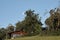 Cozy rural house surrounded by green trees under a blue clear sky