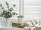 Cozy rustic home still life. On the bright window jug of dry branches,  knitted blanket, books and succulent flower. Concept of a