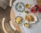 Cozy served homemade summer breakfast - pancakes with apple sauce, vintage dishes, a bouquet of dahlias on a retro tablecloth on a