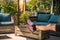 Cozy shady seating area with wooden furniture, a man puts his legs on the table to relax