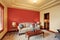 Cozy sitting room with antique beige sofa and red wall behind.