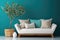 Cozy sofa with white cushions and tree in big wooden pot against teal wall with frame