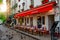 Cozy street with tables of cafe in quarter Montmartre in Paris,