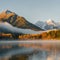 Cozy Sunrise: Morning Fog Blanket over Mountain Lake