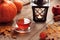 Cozy thanksgiving background with pumpkins, autumn leaves, and a mug of hot warming tea