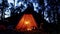 Cozy tipi with oil lamps and camp fire in a dark forest