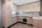 Cozy well designed modern beige luxury clean kitchen with light minimalism pastel home interior. 3d render