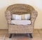 Cozy wicker armchair with rustic cushion