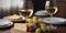 Cozy wine tasting setting two glasses of white wine, cheese, and grapes. A warm and inviting atmosphere for a relaxed