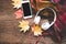 Cozy winter background, cup of hot coffee with marshmallow and headphone music, smart phone,warm knitted sweater, vintage tone.