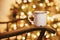 cozy winter holidays. warm atmospheric moment . mug with hot drink on old wooden chair on background of golden beautiful