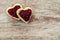 Cozy wooden background, with 2 heart-shaped sandwich bread in a corner, with strawberry jam, love concept, for Valentine`s Day,