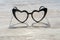 Cozy wooden background, with a heart-shaped glasses that is reflected in the wood, love concept, for Valentine`s Day, Mother`s D