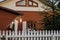 Cozy wooden house behind a white fence