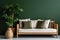 Cozy wooden sofa with white cushions near dark green wall. Side table with houseplant and potted tree.