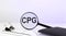 CPG - Consumer Packaged Goods concept. Magnifier glass with text with notebook and pen