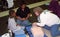 A CPR instructor teaches a boy and his mother at a communityeventr