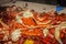 Crab claws and crawdads and shrimp piled on a paper covered cable with ears of corn and onions at a seafood boil - shallow focus