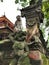 A crab-eating macaque monkey on the top of religious figure at a balinese hindu temple on Bali island in Indonesia