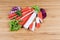 Crab sticks and variegated lettuce leaves on cutting board