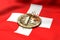 Cracked Bitcoin coin on Swiss flag. Bad Bitcoin condition in Switzerland concept. 3D Rendering