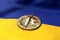 Cracked Bitcoin coin on Ukrainian flag. Bad Bitcoin condition in Ukraine concept. 3D Rendering