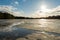 Cracked ice melts under the sun on a forest lake. Spring landscape with forest pond during sun down