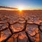 Cracked mud sand in a desert flood plain against a golden sunset background mud cracks.