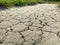 Cracked Sidewalk in Urban Area. Cracked dirt road with cracks in the clay structure of the soil.