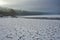 Cracked and snowy empty bottom of a dam - a silent cloudy winter country