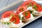 Cracker with mozzarella, tomato quarters