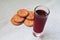 Crackers or bakery food and glass with red drink stay on white fabric tablecloth. Bread or other baked goods, juice, wine, soft