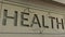 Cracking HEALTH word on the stone facade