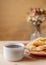 Crackled crispy cookies with sugar on a plate and a cup of coffee on a wooden table.