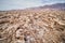 Cracks in ground of salt flats with eroded salt formations in Death Valley