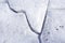 Cracks in ice. Natural background. Close up. A thick layer of ice on the frozen river. The concept of caution and the arrival of s