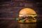Craft beef burger with cheese and rocket leafs on wood table and rustic background