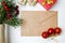 Craft bottle tied with twine with Christmas tree branches, hawthorn, craft envelope and toys on a white wooden background